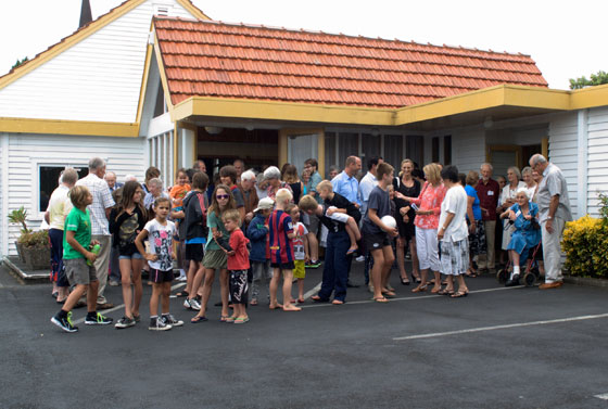 Church family standing in front of the Mairangi Presbytarian Church.